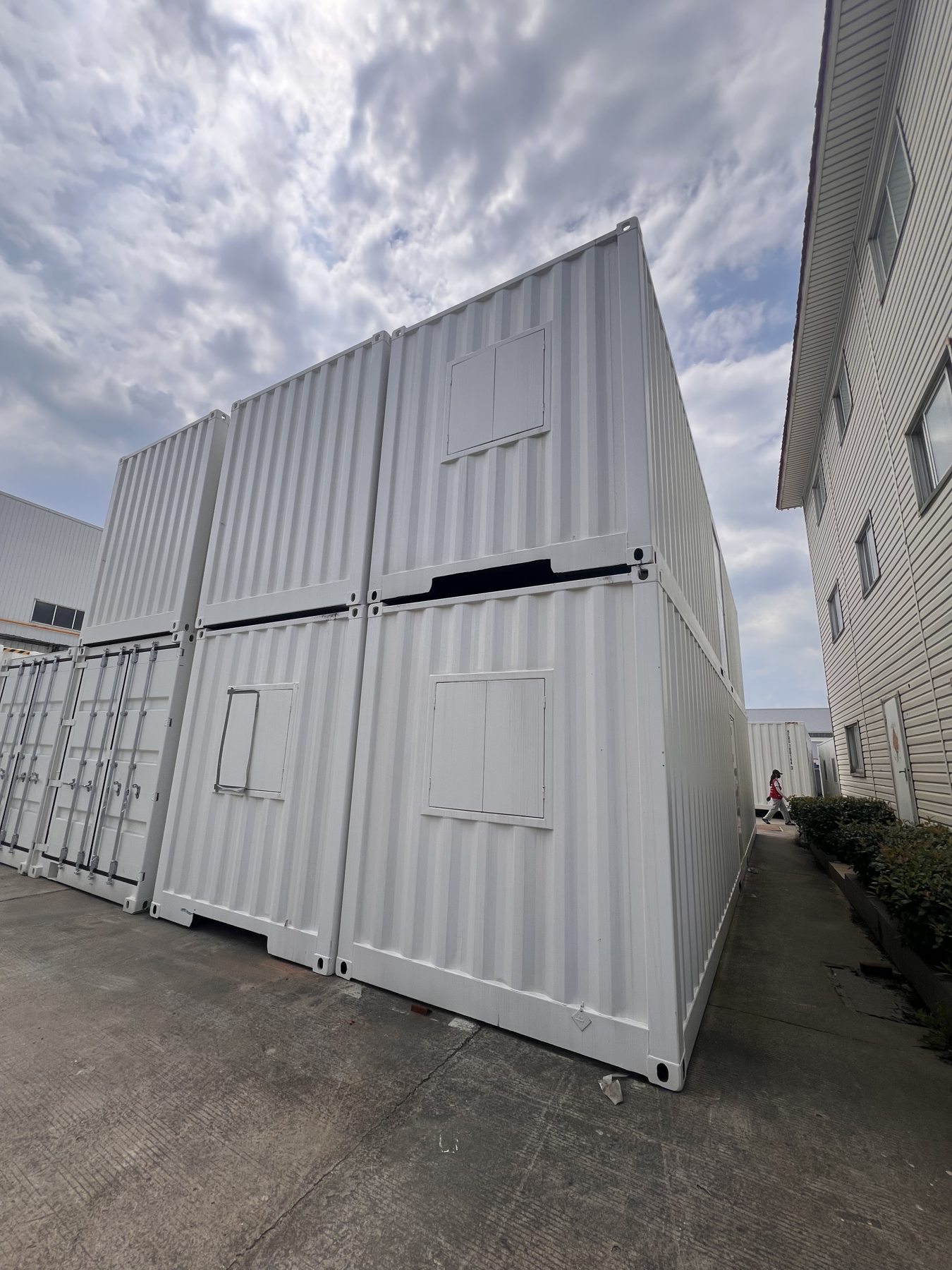 Stacked white modular units photographed at a manufacturing partner's facility