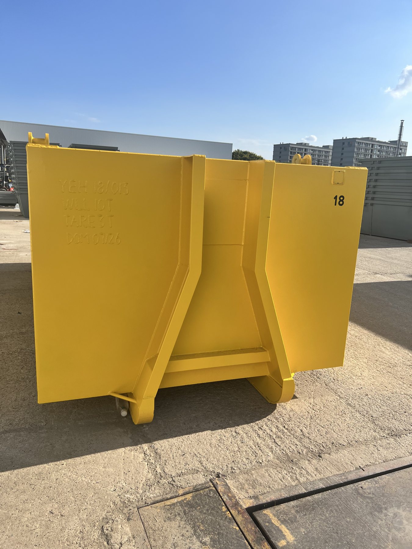 Yellow steel waste container outside the factory